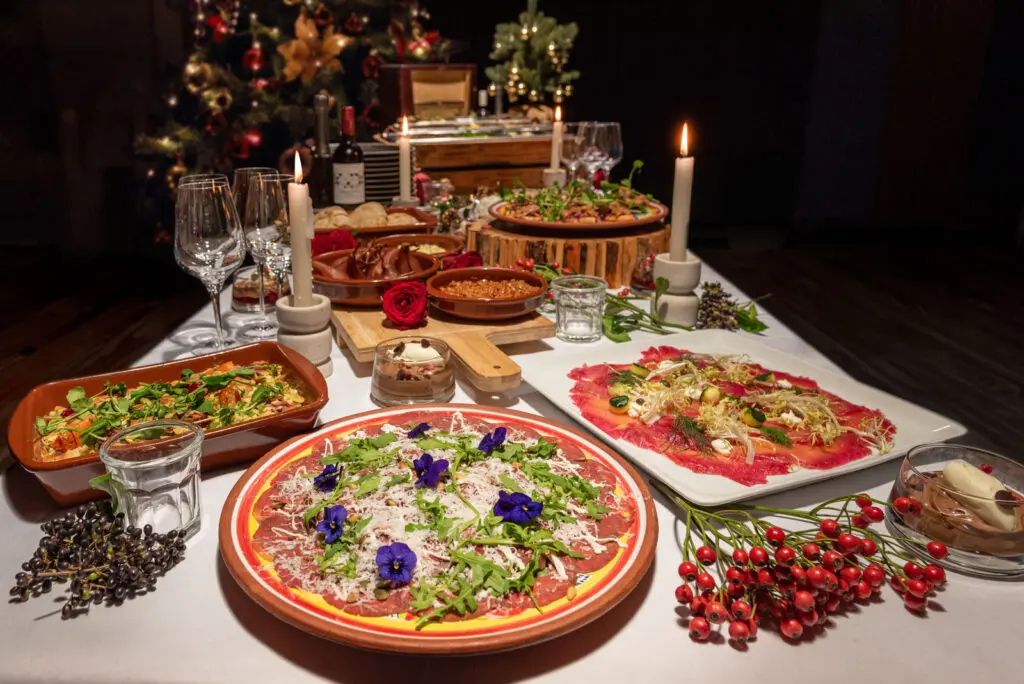 Luxe koude kerstgerechten op een gedekte tafel bij kaarslicht