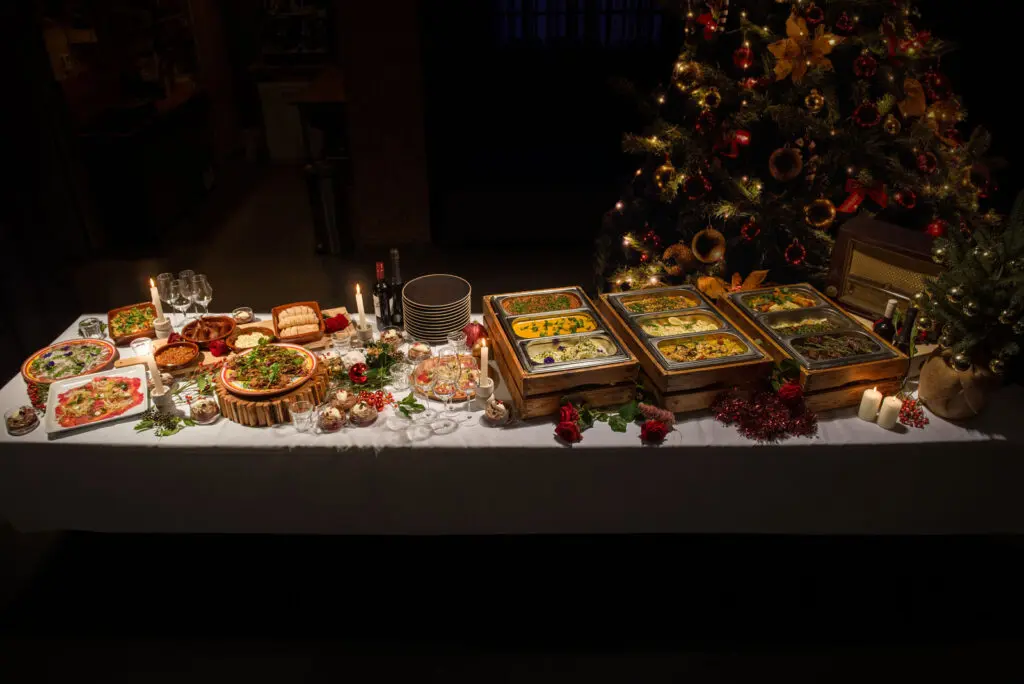 Kerstbuffet van De Eetklub op een lange tafel naast de kerstboom