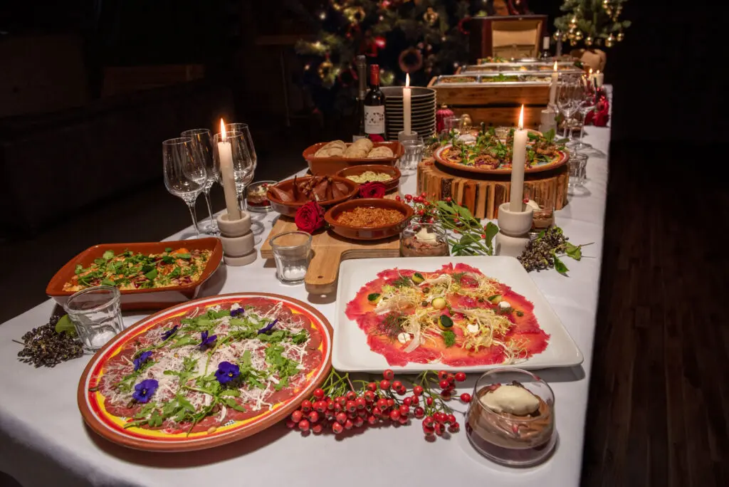 Gedekte kersttafel met koude gerechten, salades en kaarsen